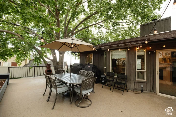 Expansive concrete deck with a black metal railing and string lighting