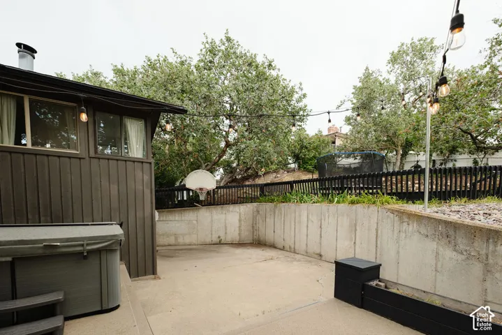 Outdoor patio with concrete surfacing, adjacent to a wood-sided structure