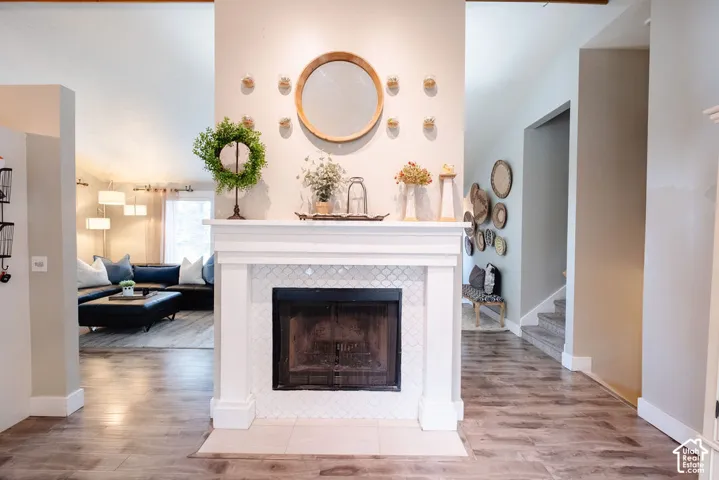 White fireplace with tile surround, wood-finish flooring, and recessed hearth