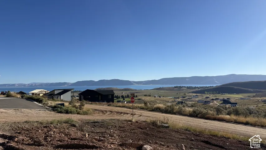 Expansive distant water body, natural landscape, rolling hills, and distant residences