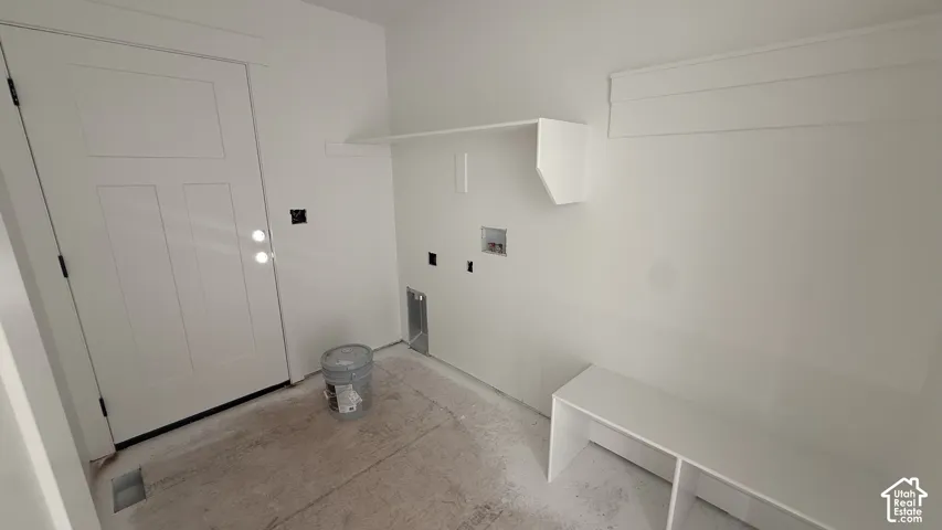 Built-in shelving, integrated laundry hookups, and a panel door with hardware
