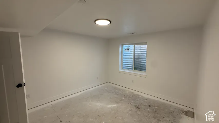 Interior space featuring white painted walls and a single window