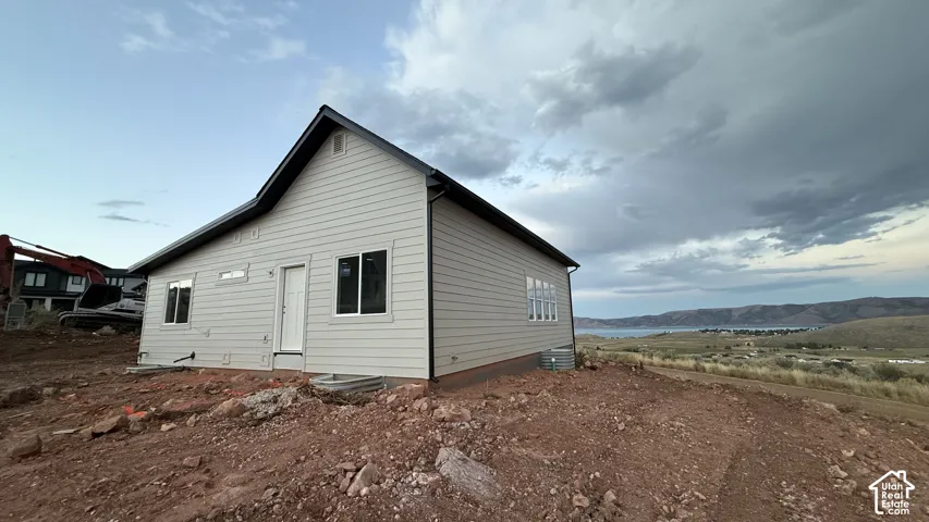 Beige horizontal siding exterior, black trim, and white window frames