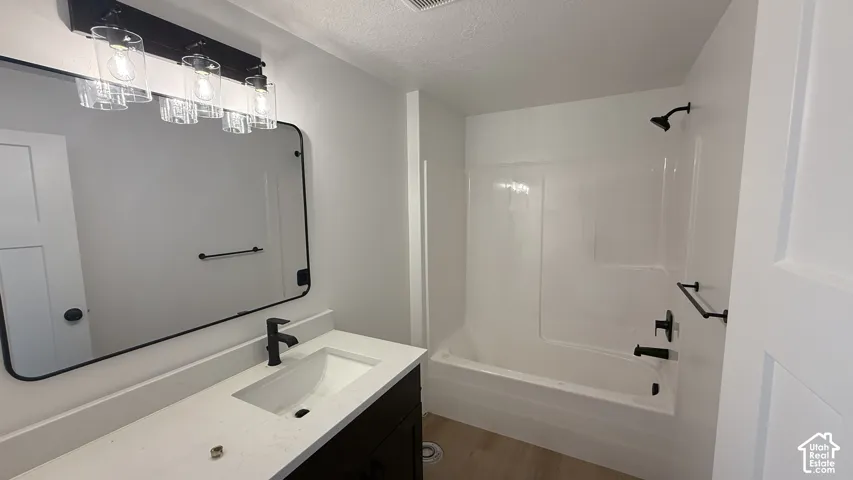 White vanity with an integrated sink, matte black faucet, and a rectangular mirror