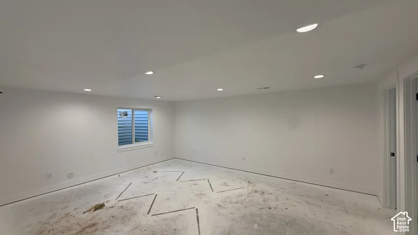 Recessed lighting throughout, white painted walls, window with blinds, and white trim