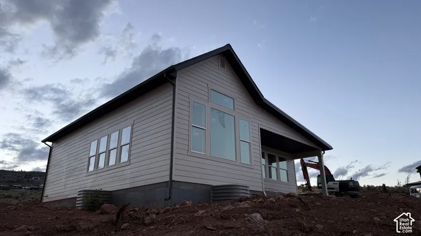 Siding exterior with a covered patio and multiple windows