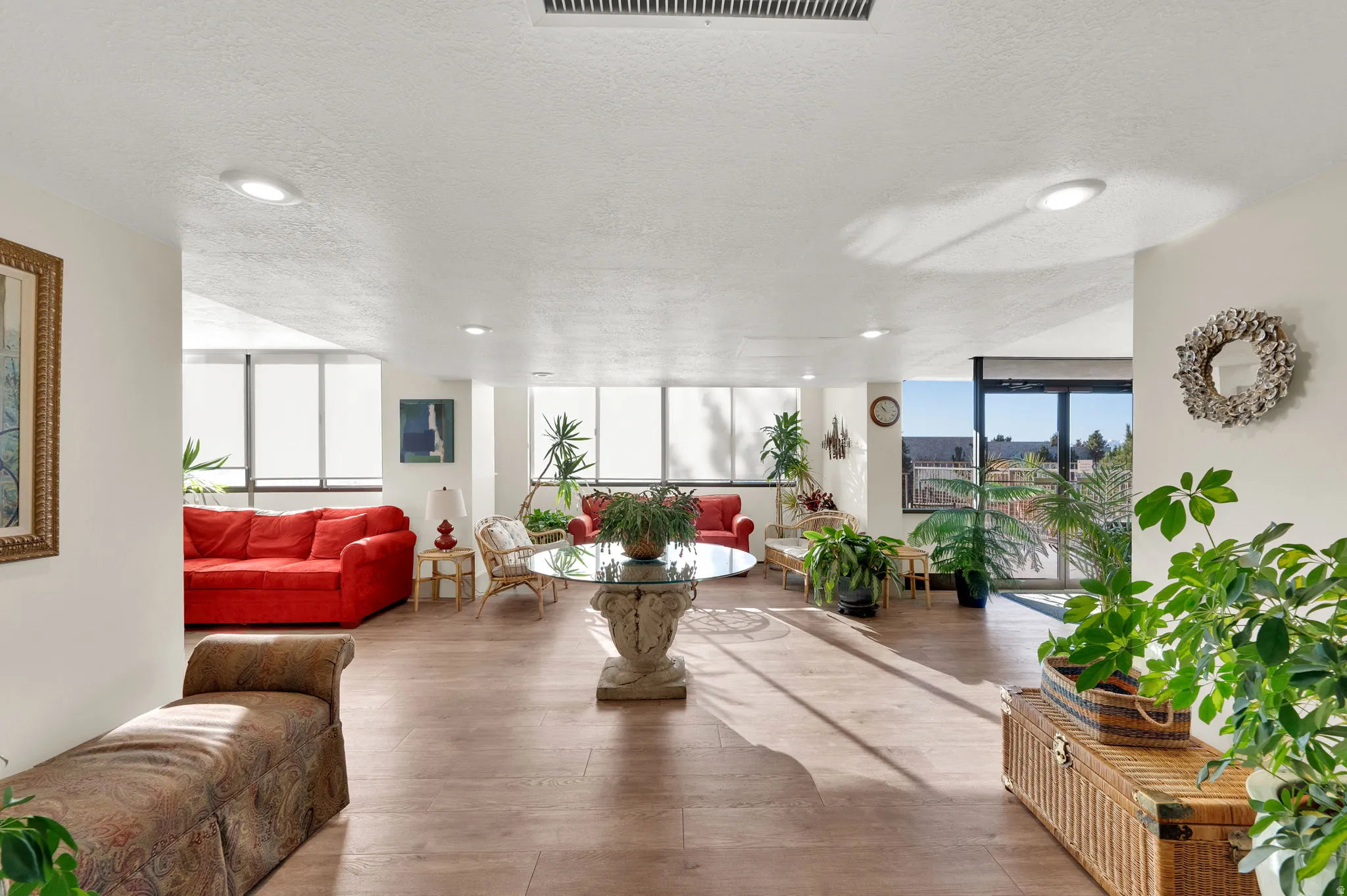 Expansive interior with wood-finish flooring, recessed lighting, and abundant natural light from multiple large windows