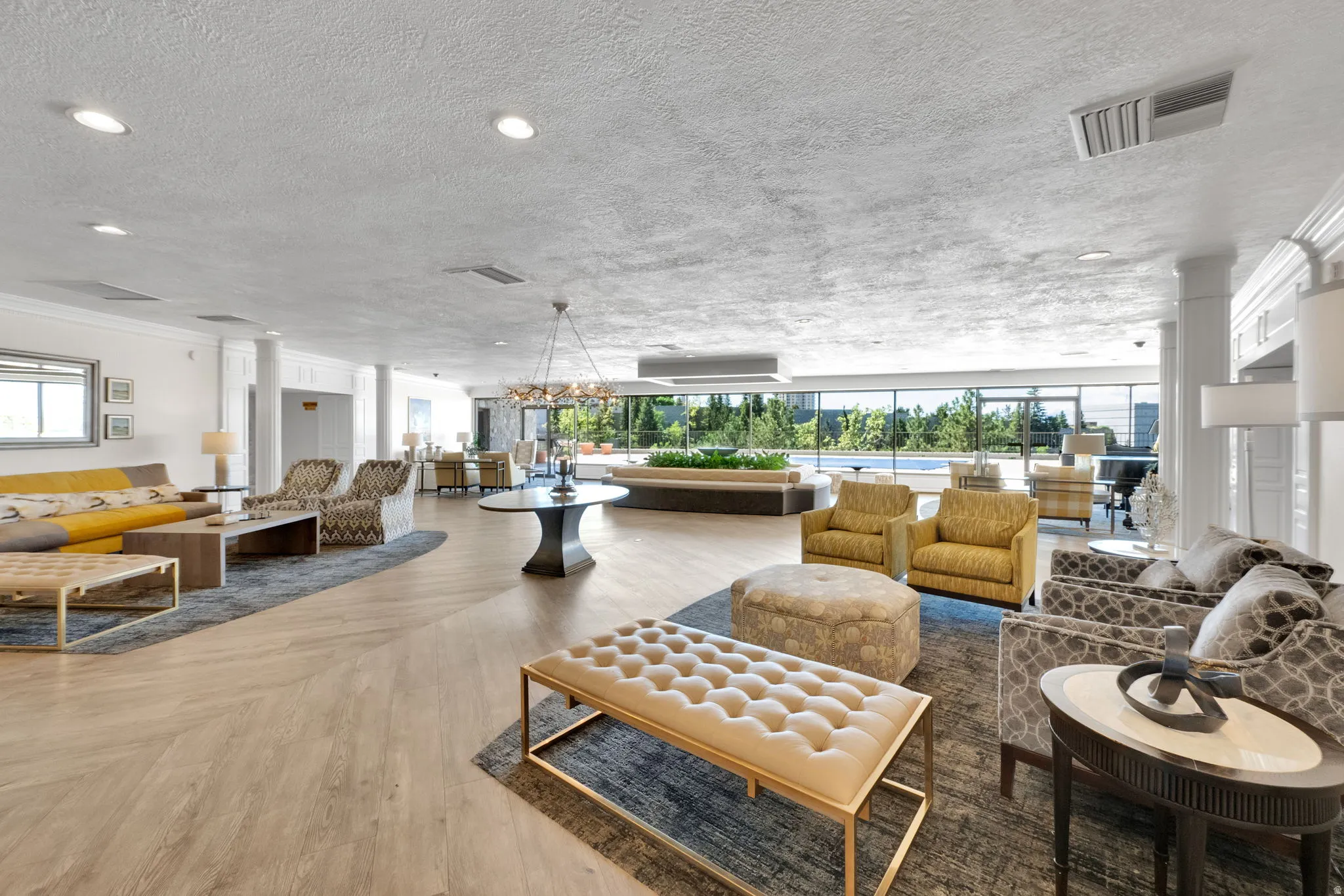 Expansive common area featuring wood-finish flooring, recessed lighting, and a decorative chandelier