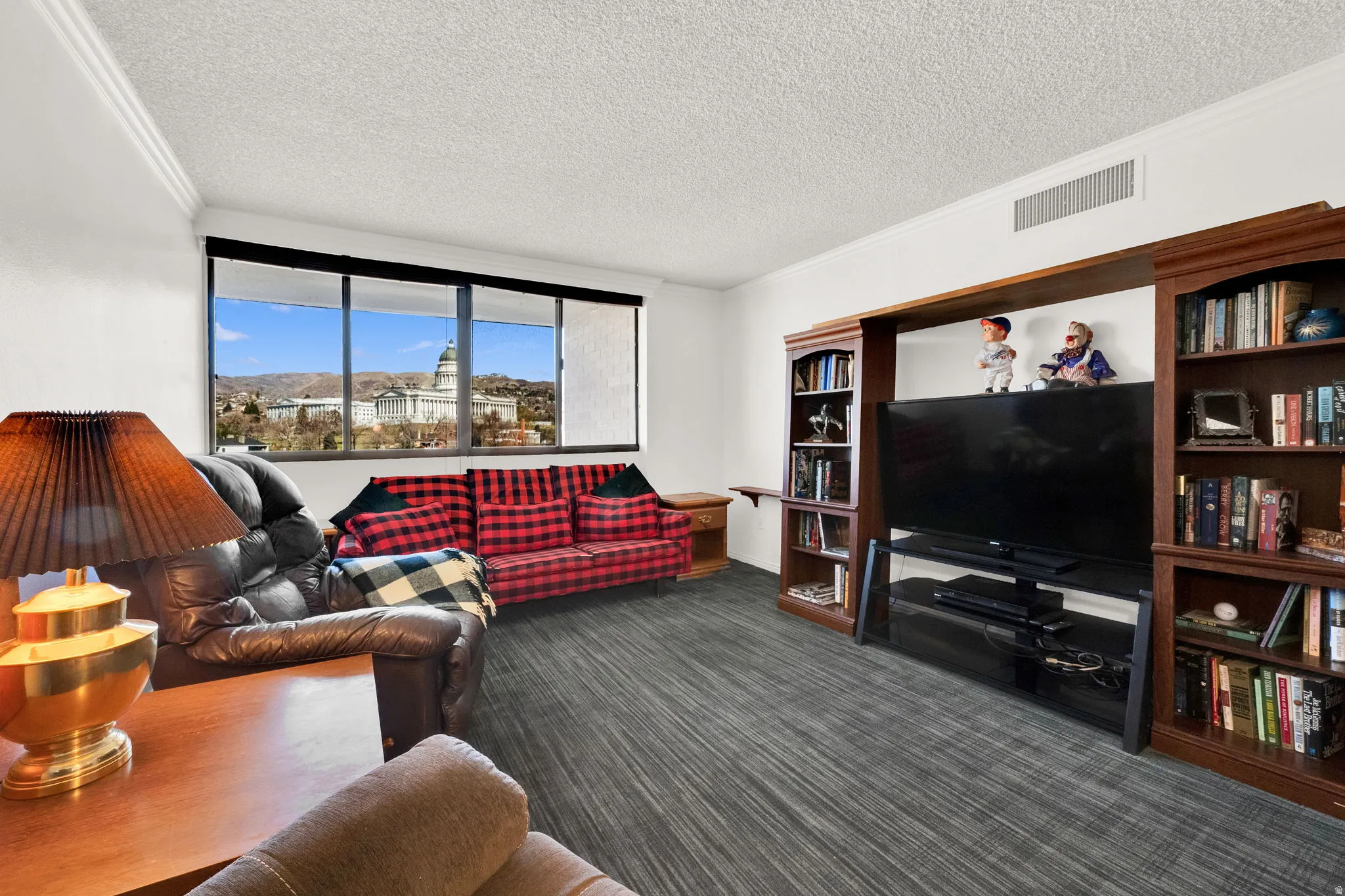 Floor-to-ceiling windows, built-in shelving, crown molding, and wood-finish flooring