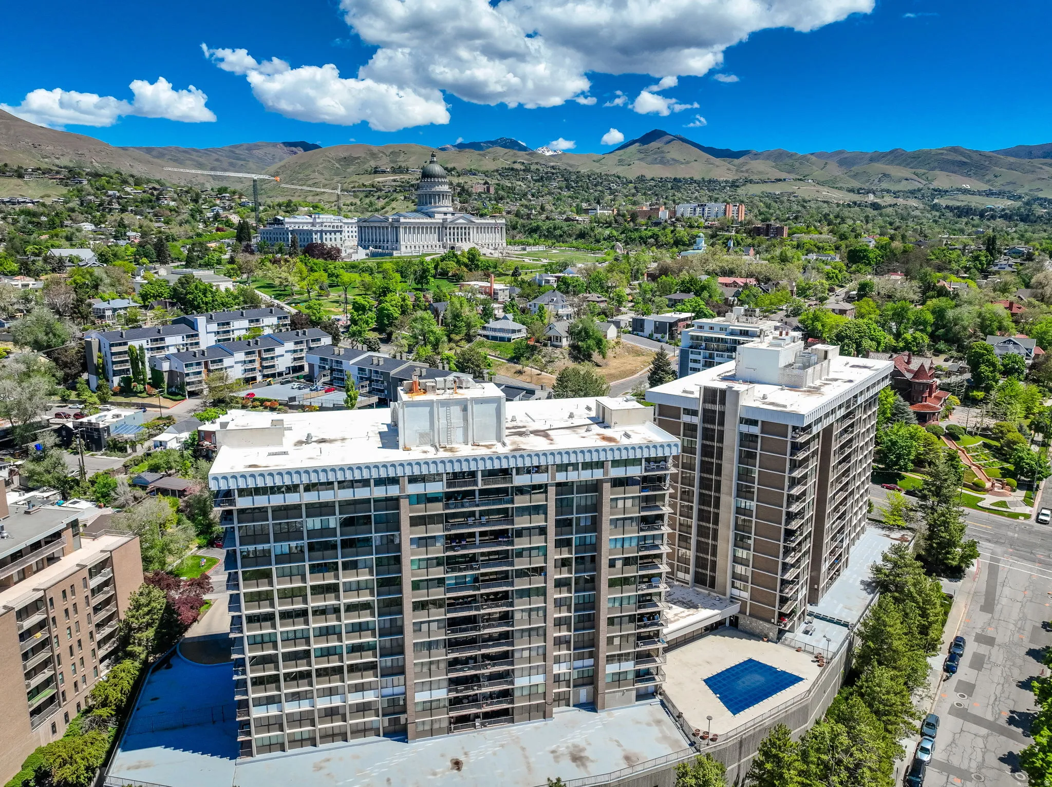 Two high-rise buildings featuring multiple balconies and a ground-level swimming pool