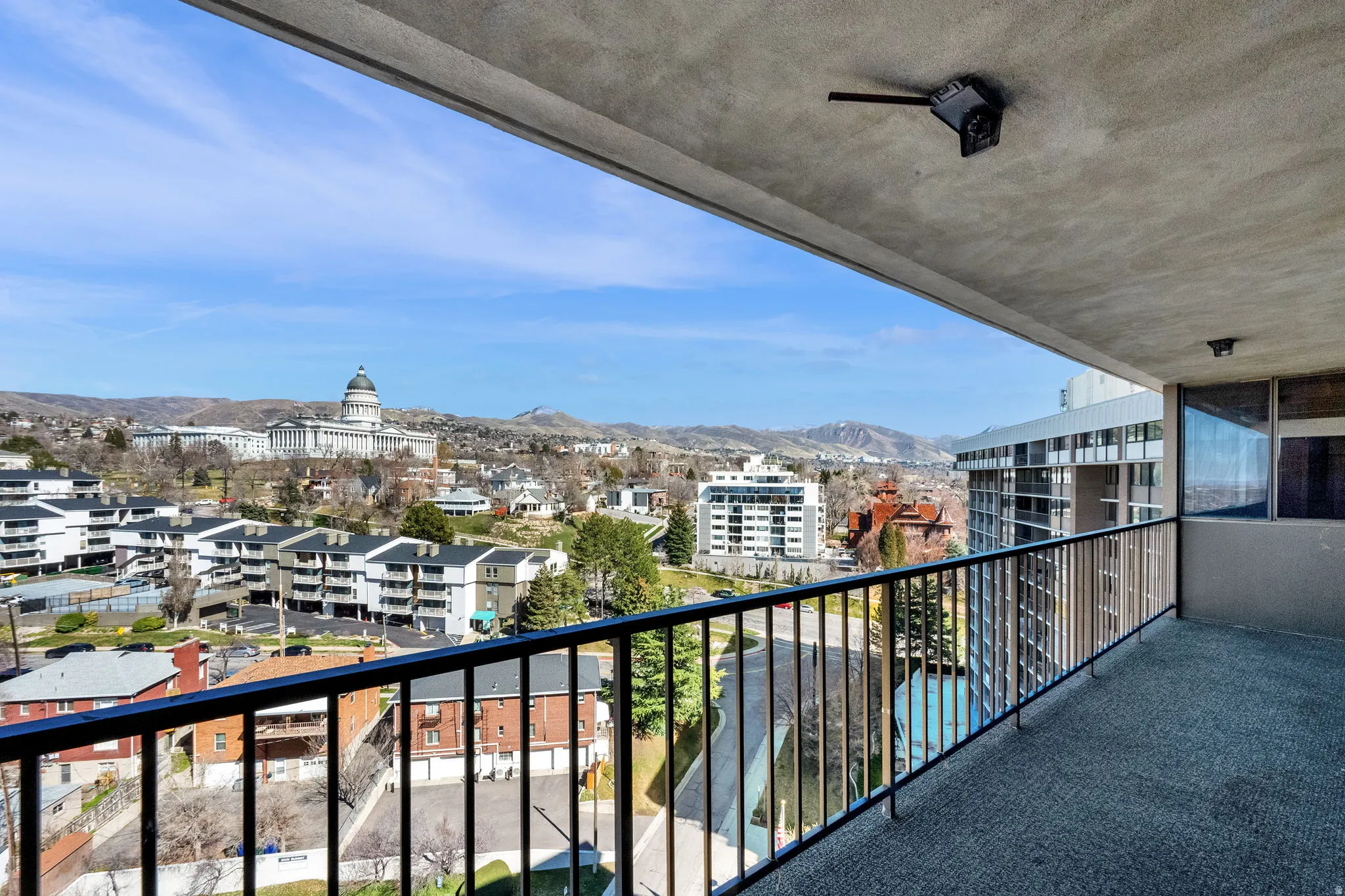 Balcony with a black metal railing and a textured concrete ceiling