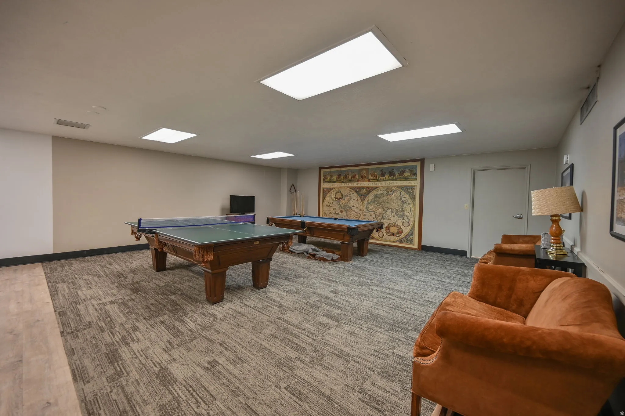 Recreation room featuring carpet flooring, recessed lighting, and a solid core door