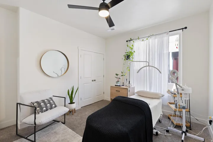 Recessed lighting, ceiling fan, double-panel doors, and a window with a sheer curtain