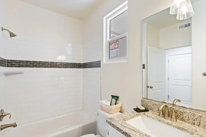 Tub/shower combination with white subway tile surround and decorative mosaic accent