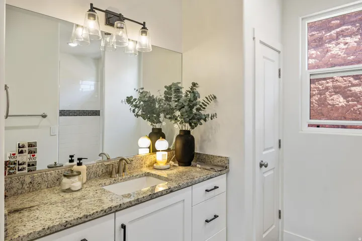 White vanity with granite countertop and integrated rectangular sink