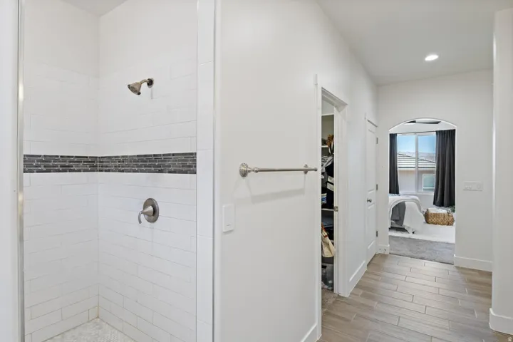 Tiled shower with decorative accent band and brushed nickel fixtures