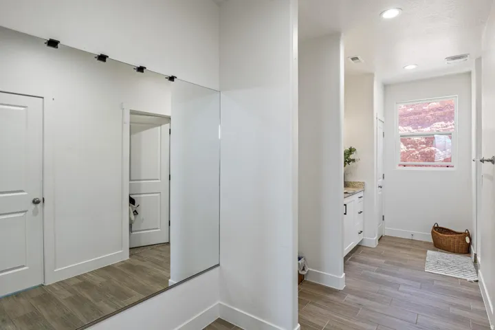 White paneled doors, recessed lighting, and wood-finish flooring