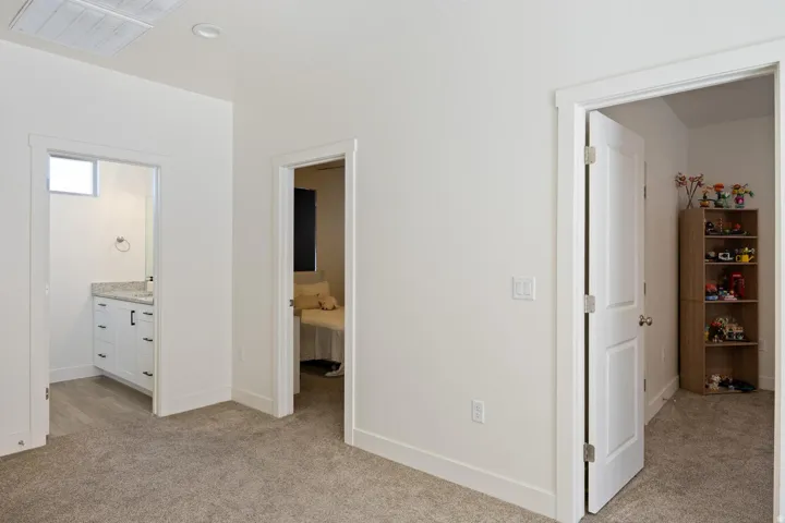 Neutral carpeting, white interior doors, and recessed lighting