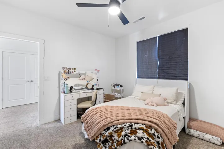 Recessed window with dark window treatments, ceiling fan with integrated lighting, and neutral wall color