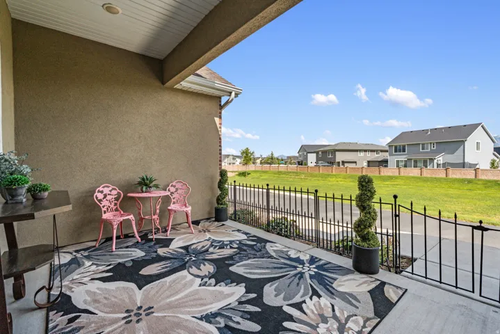 Covered patio featuring a stucco exterior, recessed lighting, and a metal fence with a gate