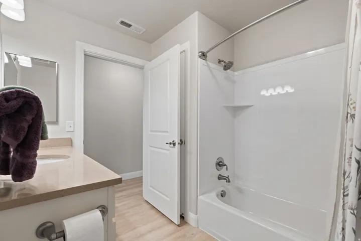 White tub and shower combination with a curved shower rod