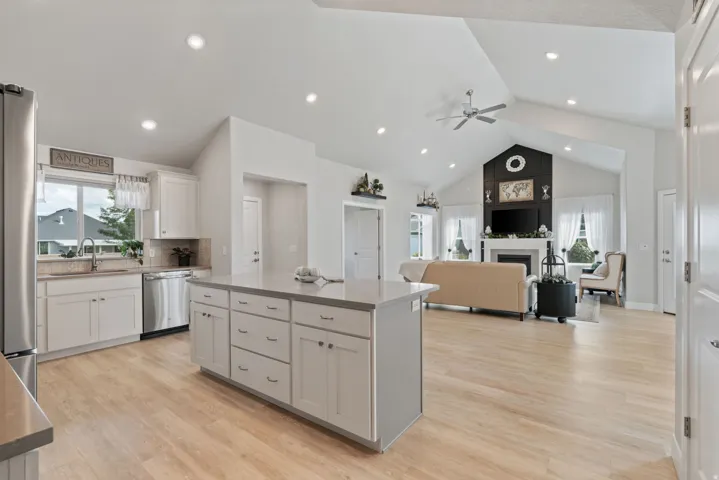 Vaulted ceilings, recessed lighting, and wood-finish flooring define this open-concept space
