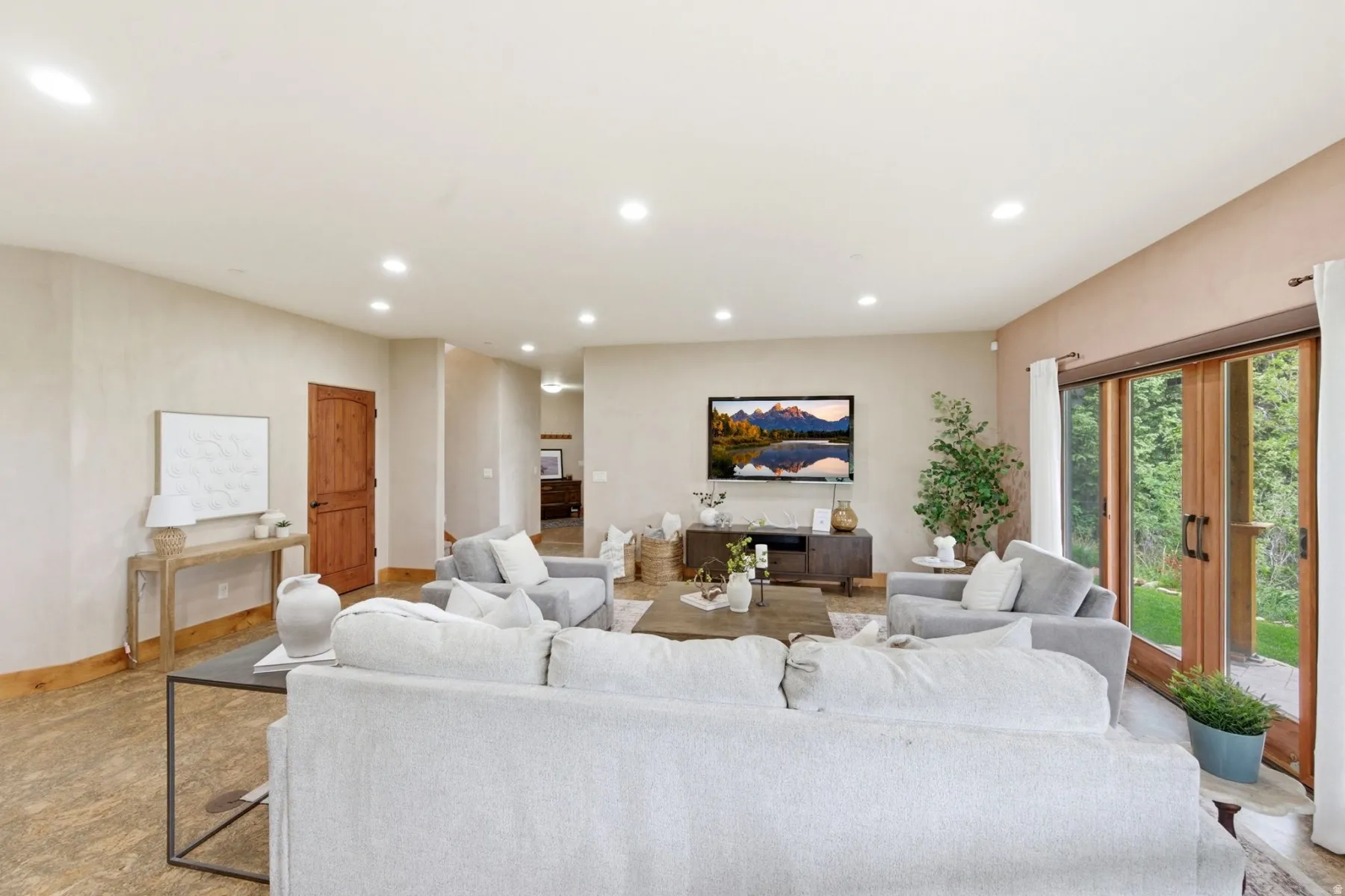 Recessed lighting illuminates the expansive living area with neutral wall finishes