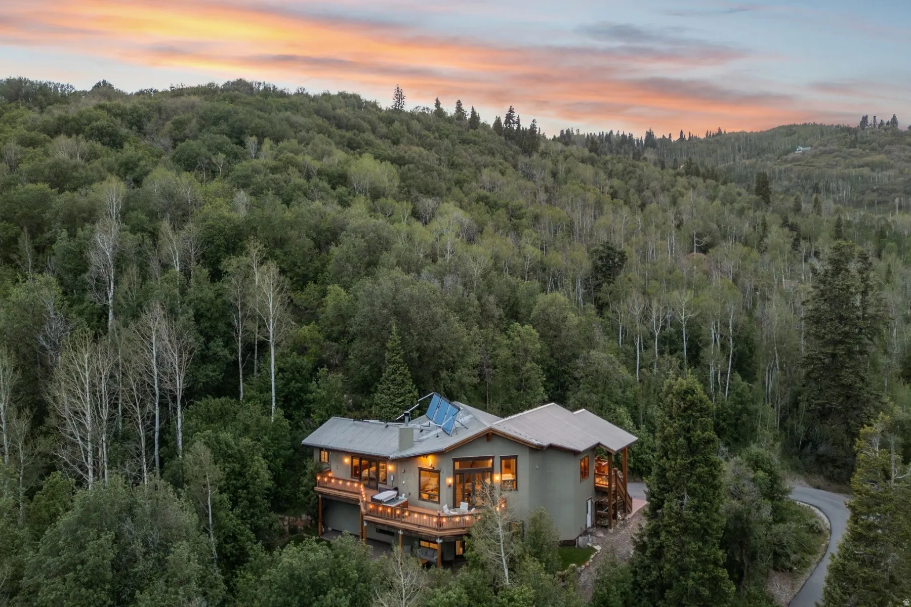 Exterior featuring multiple levels, expansive decking, a durable roof, and integrated solar panels