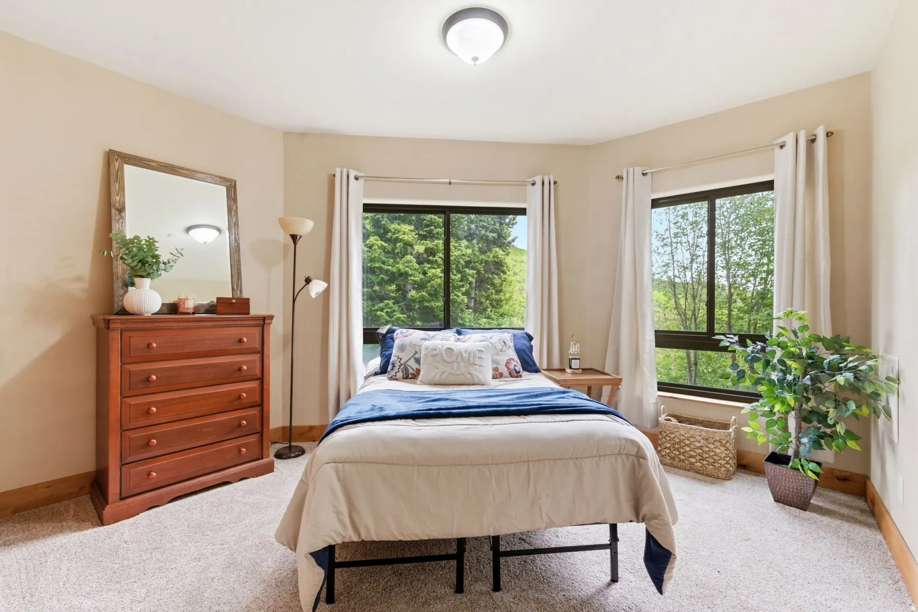 Carpeted room featuring a ceiling-mounted light fixture, two windows with surrounding trim, and wood trim details