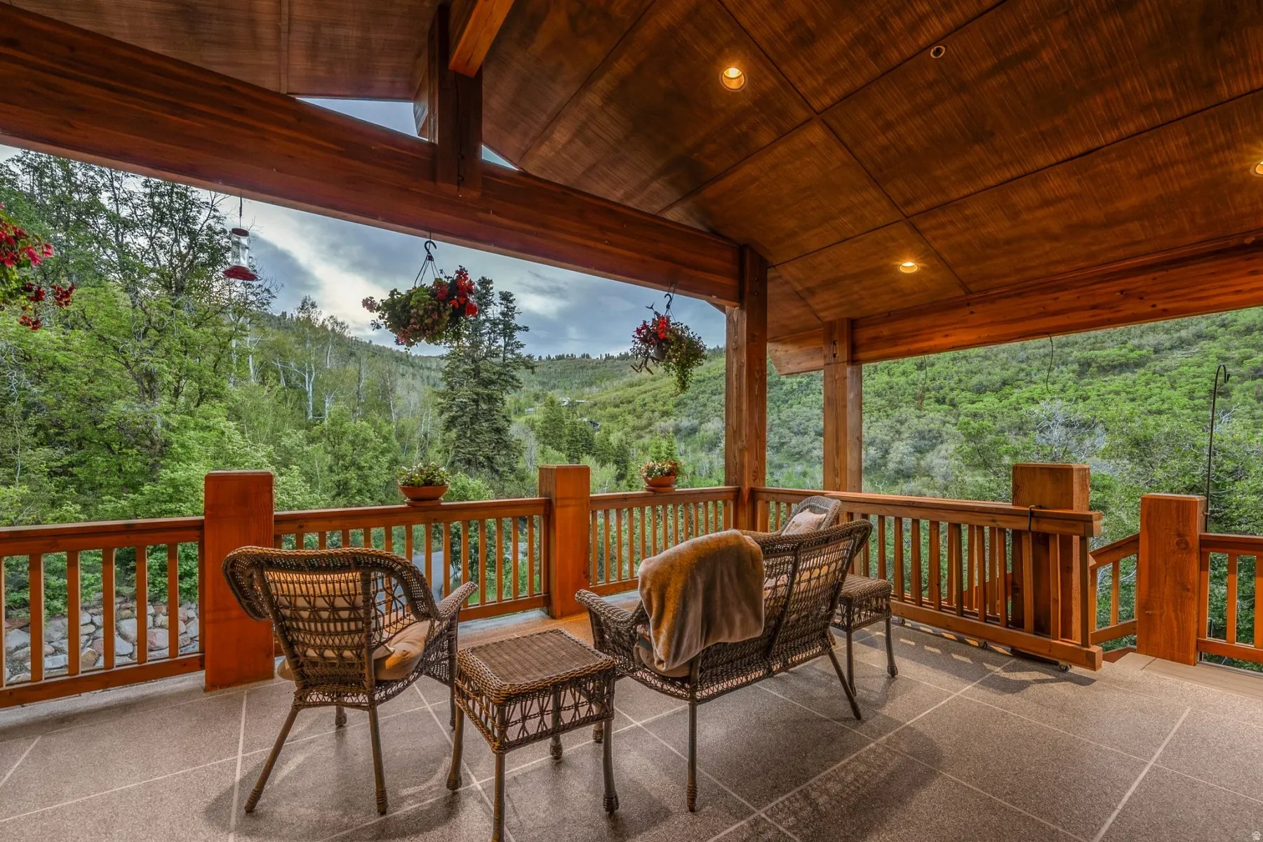 Expansive covered outdoor living space featuring a wood-plank ceiling, recessed lighting, and a wood railing system