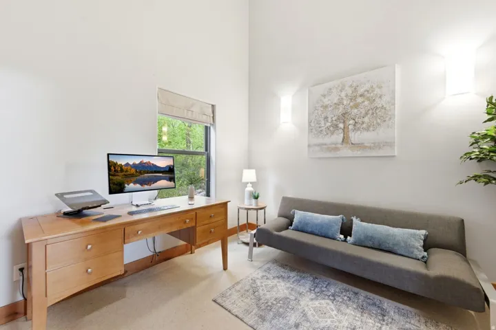 Vaulted ceiling, recessed window, light wood-finish flooring, and wall-mounted lighting fixtures