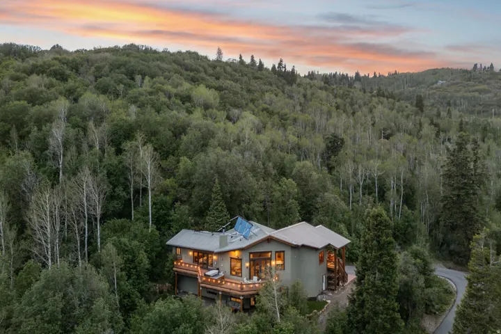 Exterior featuring multiple levels, expansive decking, a durable roof, and integrated solar panels