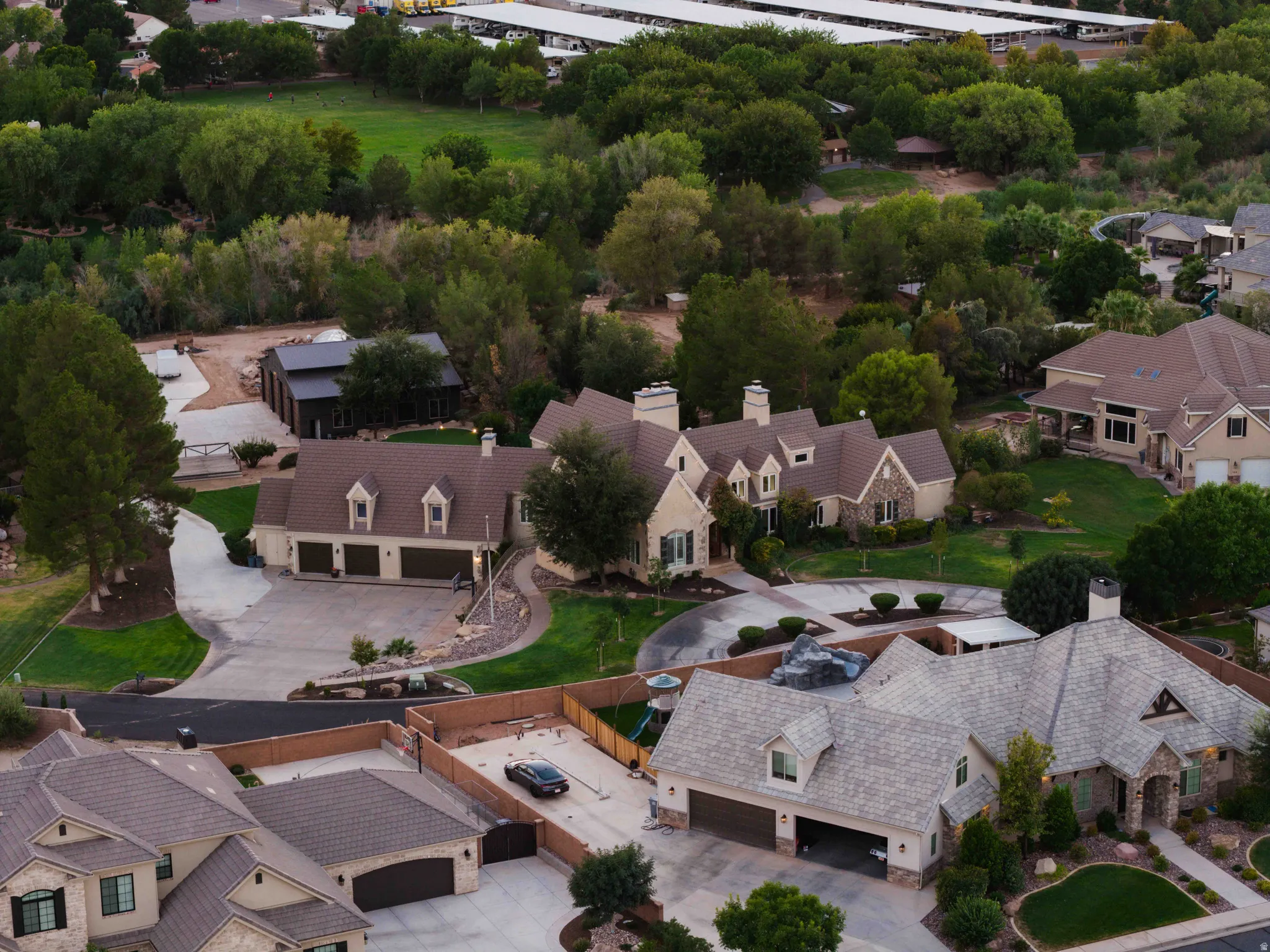 Multi-level residence featuring a stone and stucco exterior, multiple dormer windows, and a multi-car garage