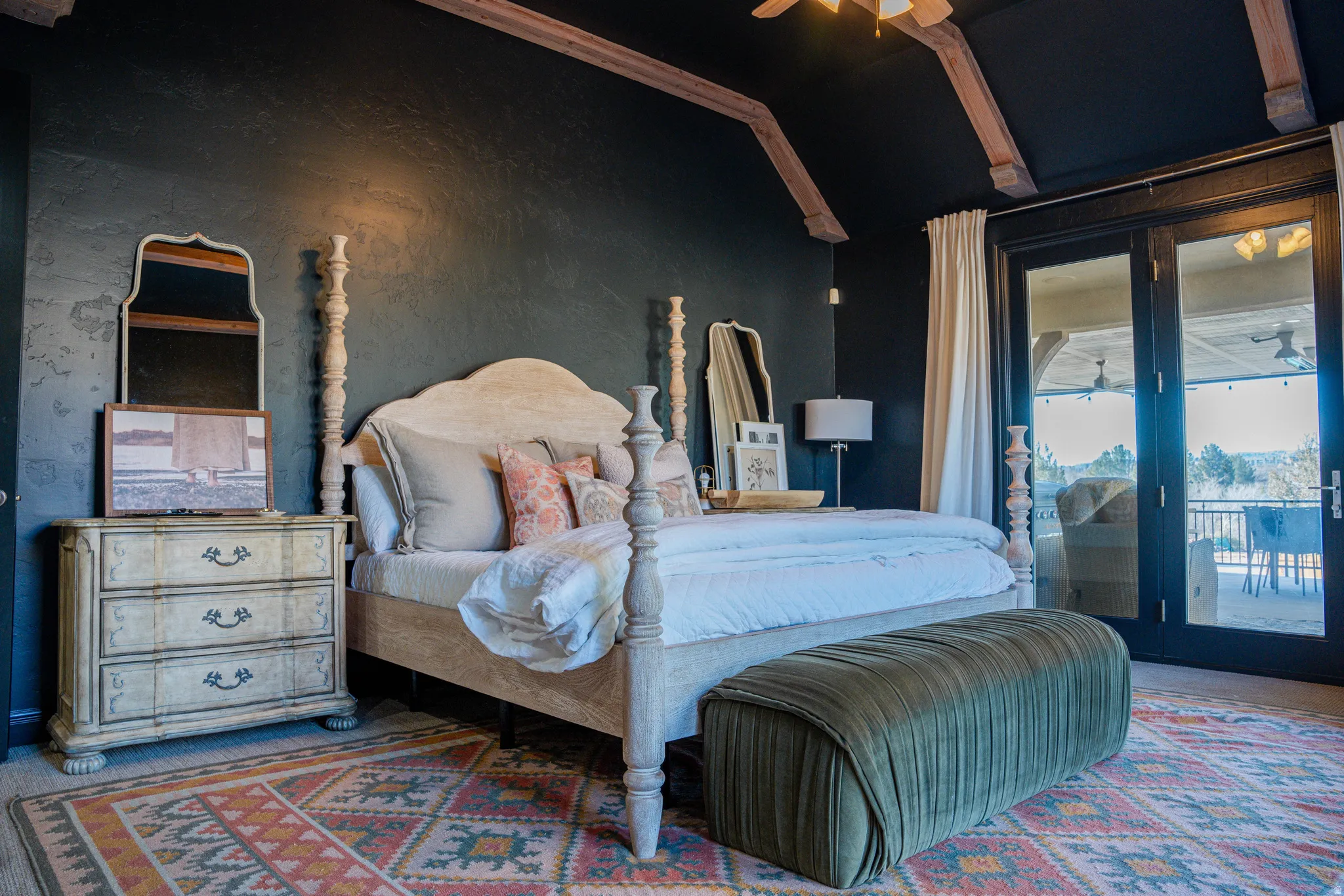 Vaulted ceiling with exposed wood beams, French doors, textured wall finish, and wood-finish flooring