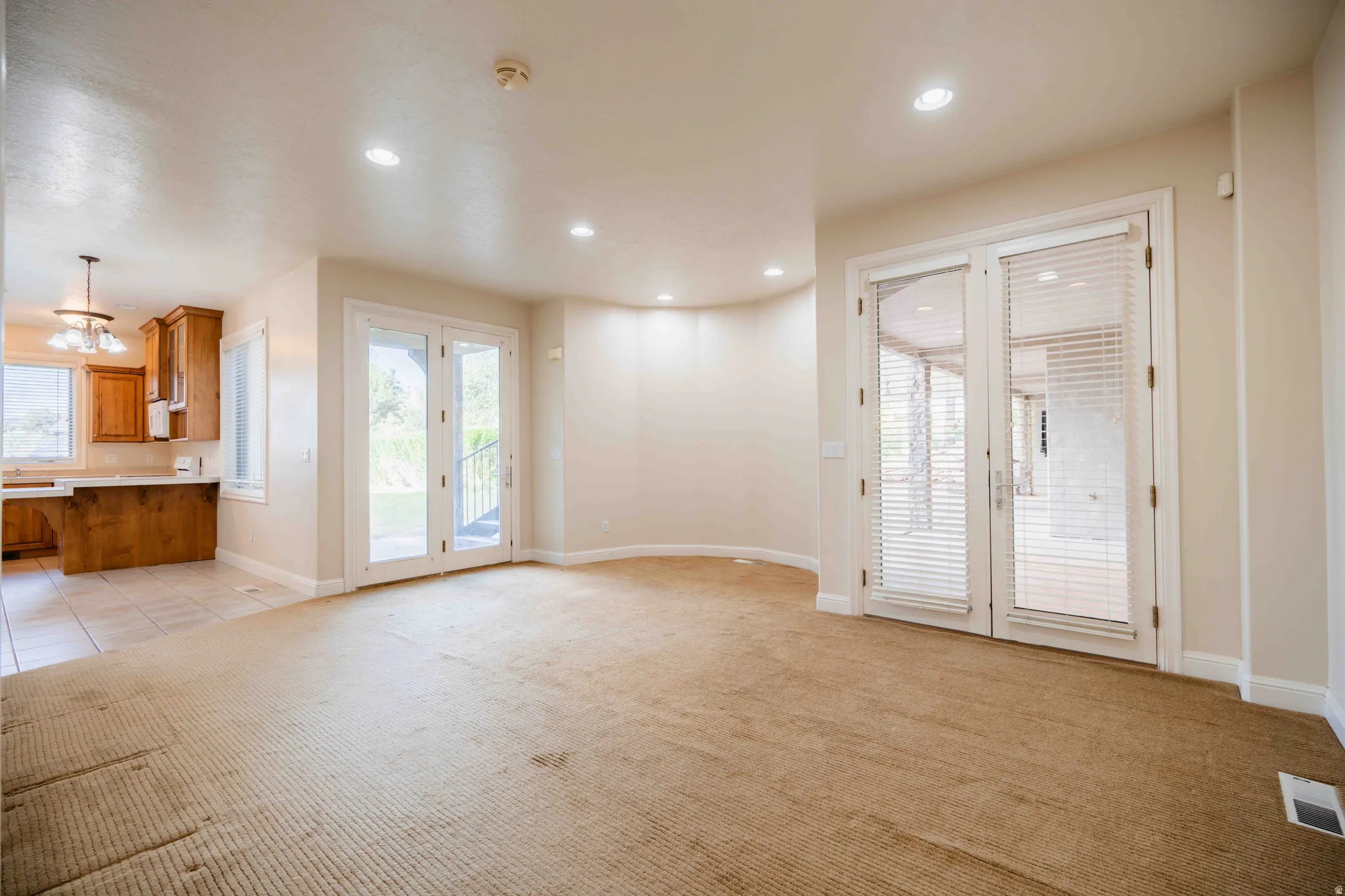 Recessed lighting illuminates neutral-toned walls and carpeted flooring
