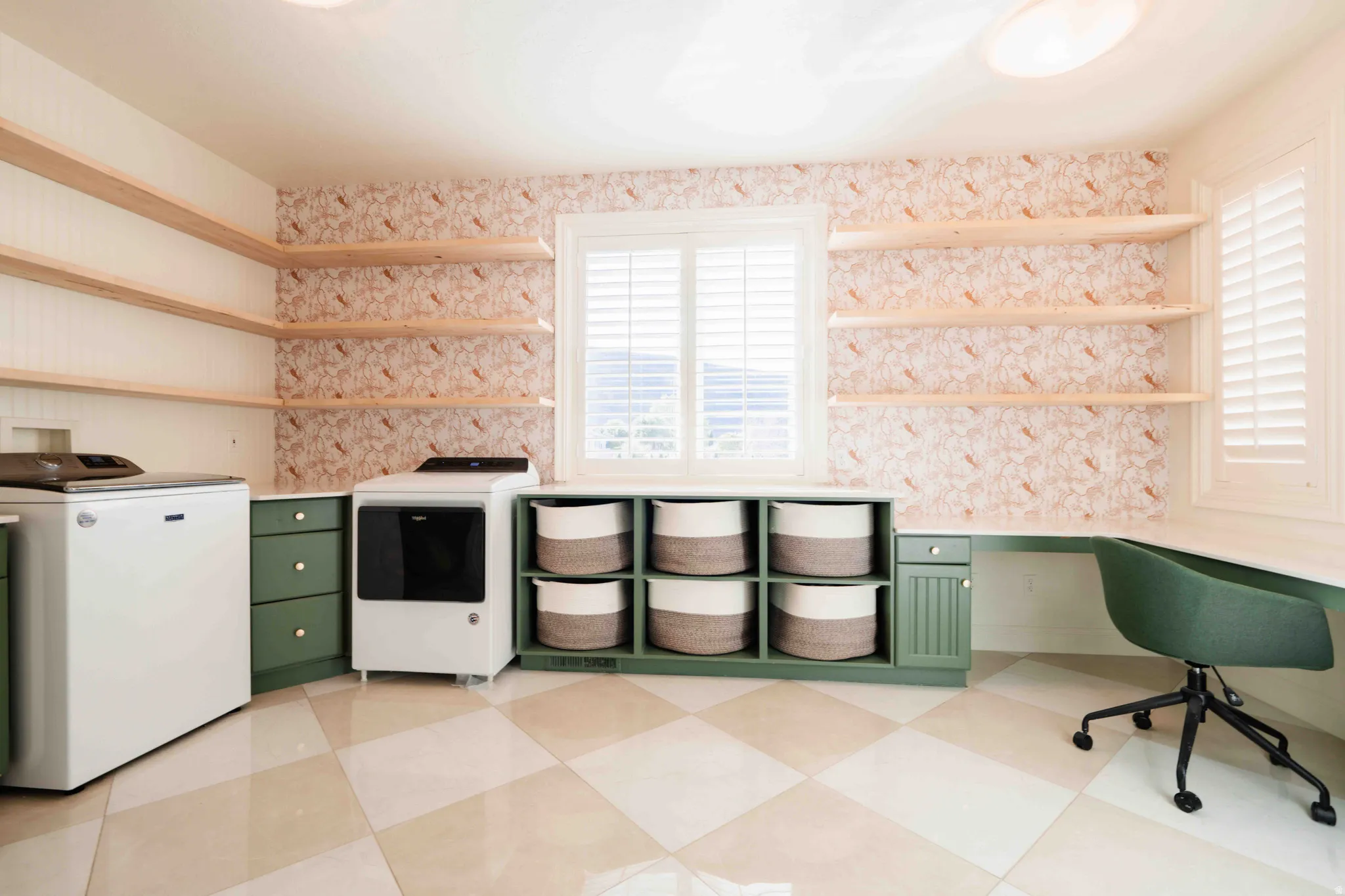 Built-in shelving, green cabinetry, checkerboard flooring, two windows with plantation shutters, and a built-in desk