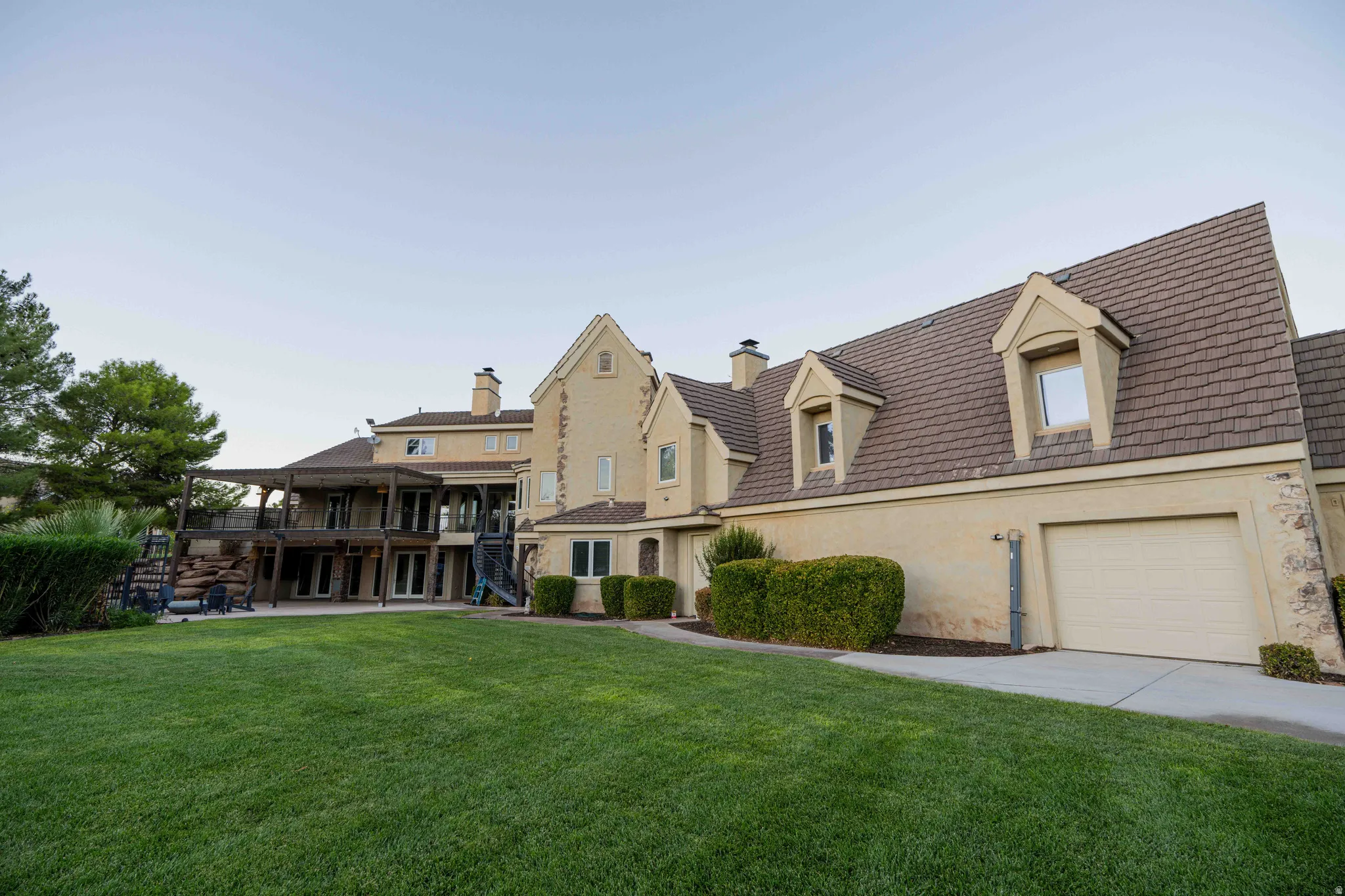 Extensive backyard featuring a lush lawn, multi-level deck, patio space, and mature landscaping
