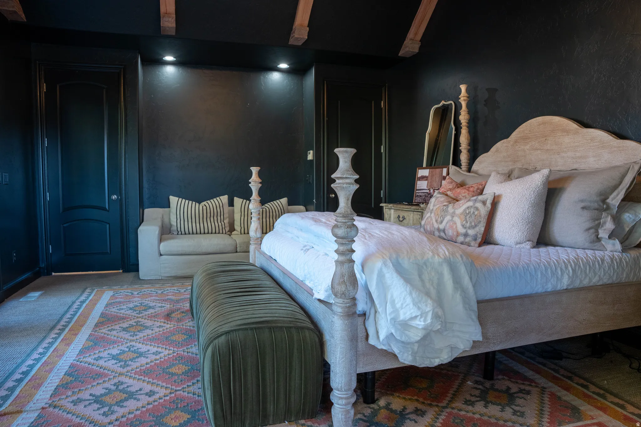 Dark-toned walls with recessed lighting, exposed ceiling beams, and paneled doors