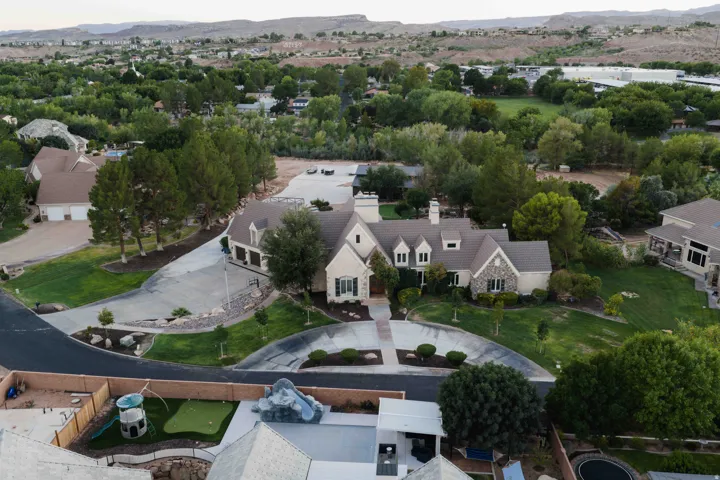 Expansive property featuring a circular driveway, mature landscaping, and multi-car garages
