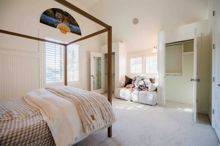 White plantation shutters over windows, recessed lighting, and a built-in closet with shelving