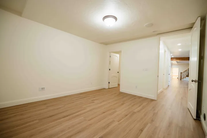 Wood-finish flooring, recessed lighting, and a white interior door