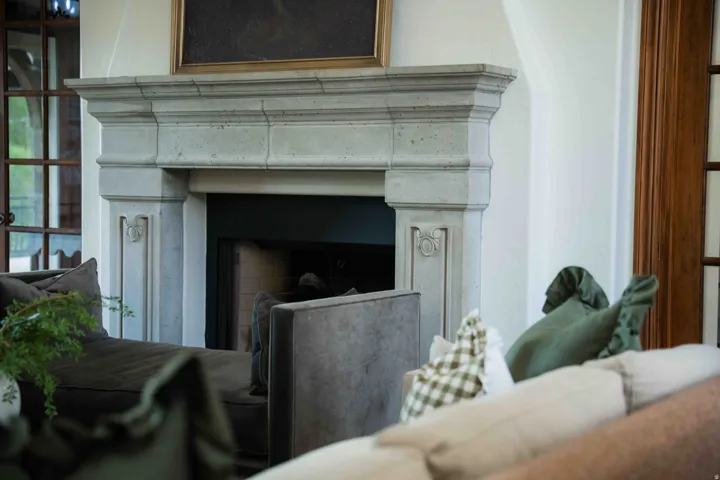 Stone fireplace with ornate detailing and a dark firebox