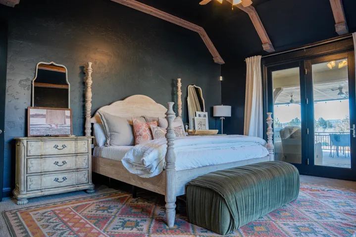 Vaulted ceiling with exposed wood beams, French doors, textured wall finish, and wood-finish flooring