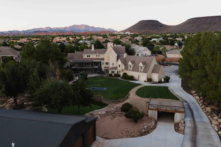 Expansive property featuring a two-story residence with multiple balconies, an in-ground pool, and a detached structure with a metal roof