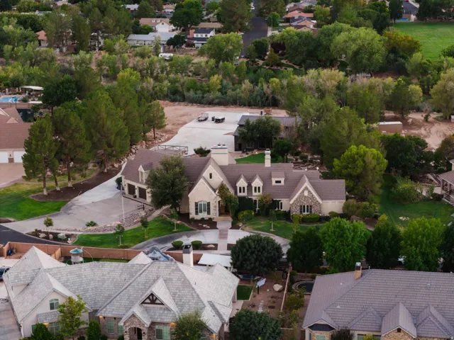 Stately residence featuring a stone and stucco exterior, multiple gables, and an attached three-car garage