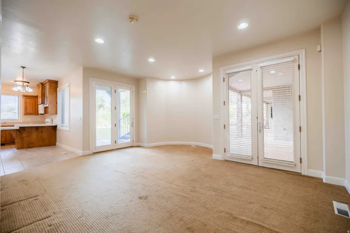 Recessed lighting illuminates neutral-toned walls and carpeted flooring