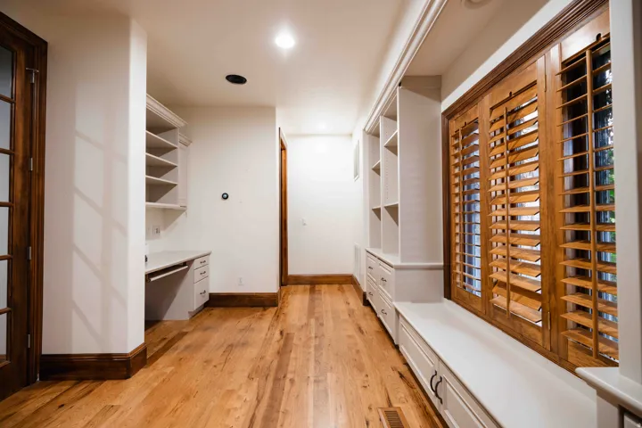 Hardwood flooring, built-in shelving, built-in desk, built-in window seat, and wood plantation shutters