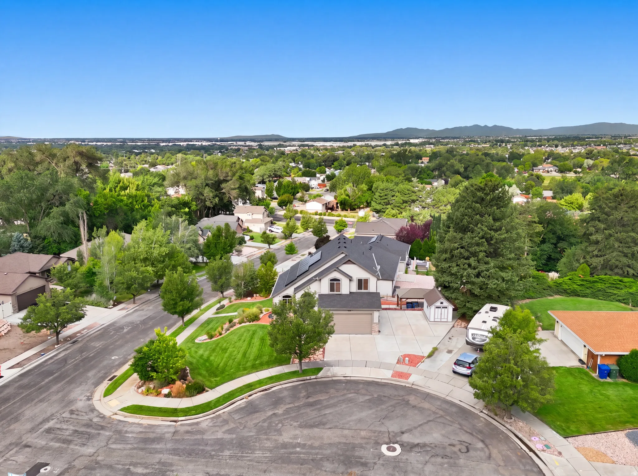 Two-story residence with a multi-car driveway, attached garage, and landscaped front yard