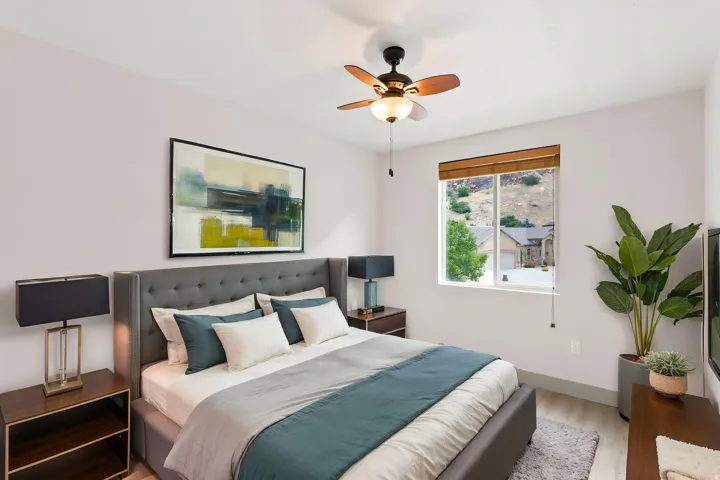 Recessed lighting, ceiling fan with integrated light, wood-finish flooring, tufted headboard, and window with natural light