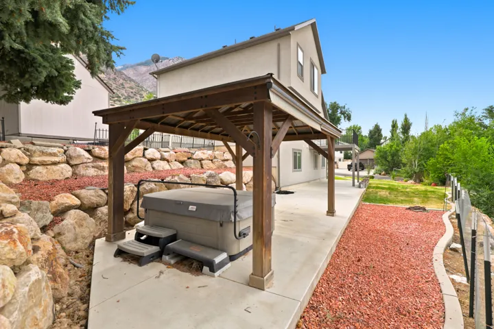 Covered outdoor spa area featuring a wooden pergola
